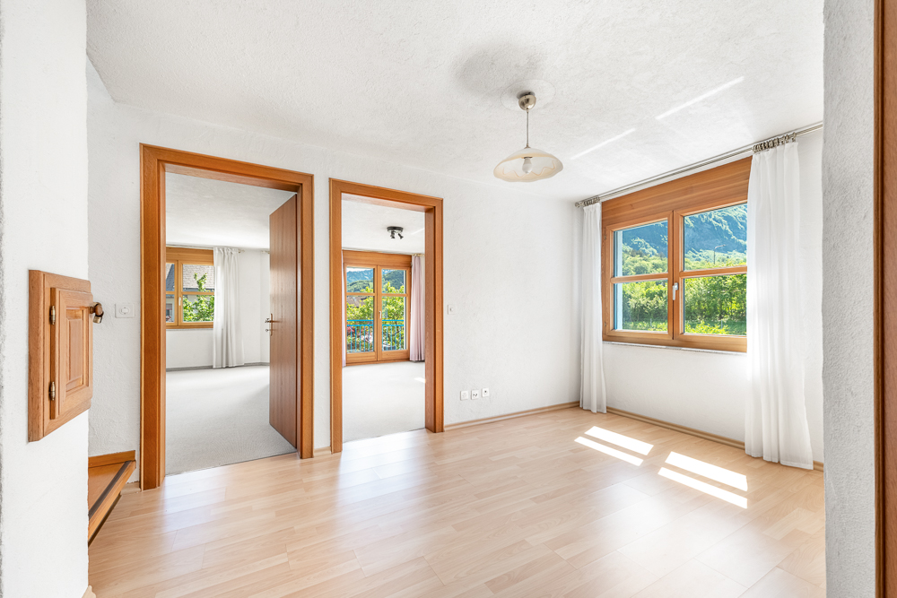 Heller Wohnraum mit Holzwindows und Bergblick