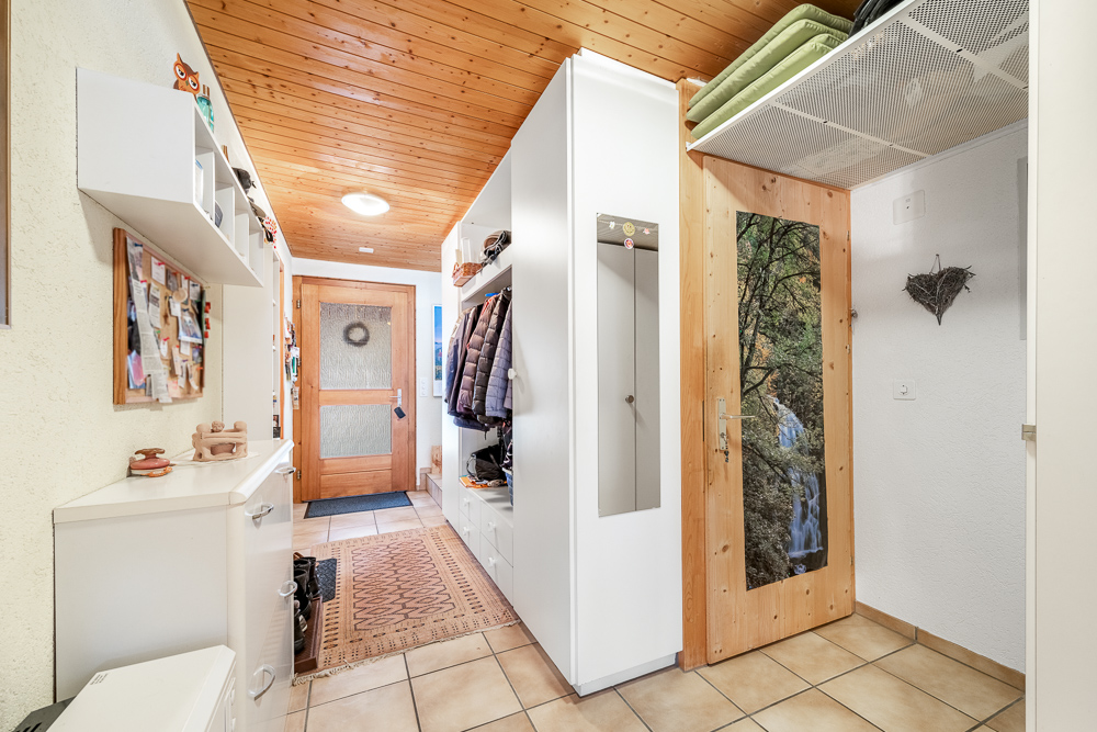 Flur mit Garderobe und Holztür