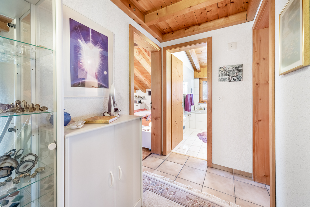 Flur mit Holzakzenten und Blick ins Bad und Schlafzimmer