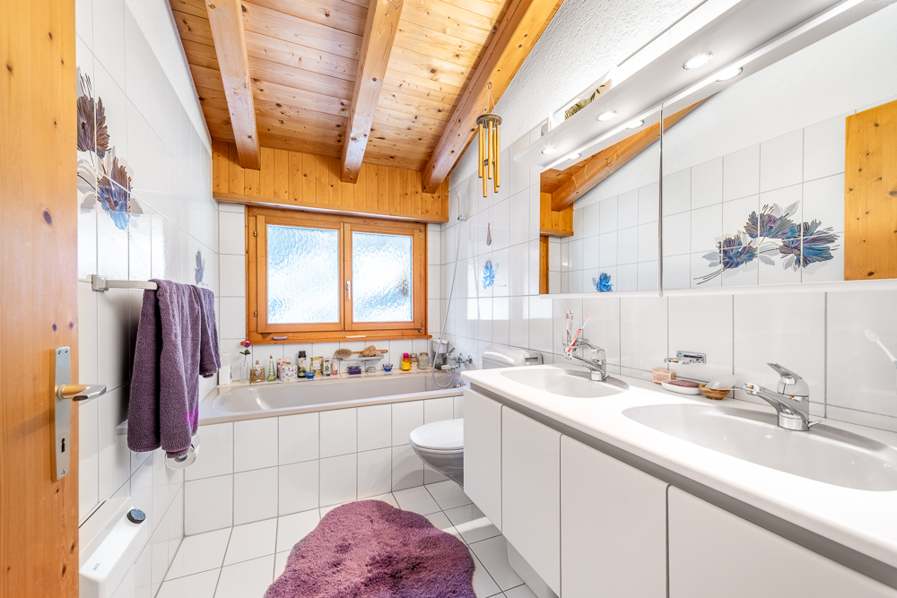 Helles Badezimmer mit Holzdecke und Doppelwaschtisch