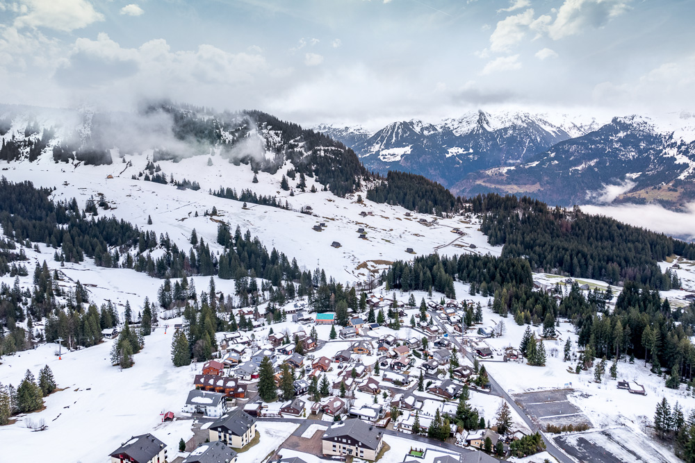 Schneebedecktes Bergdorf in alpiner Landschaft