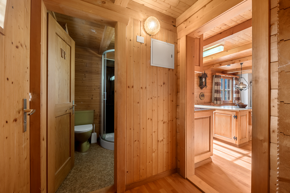 Holzvertäfelter Flur mit Blick in WC und Küche