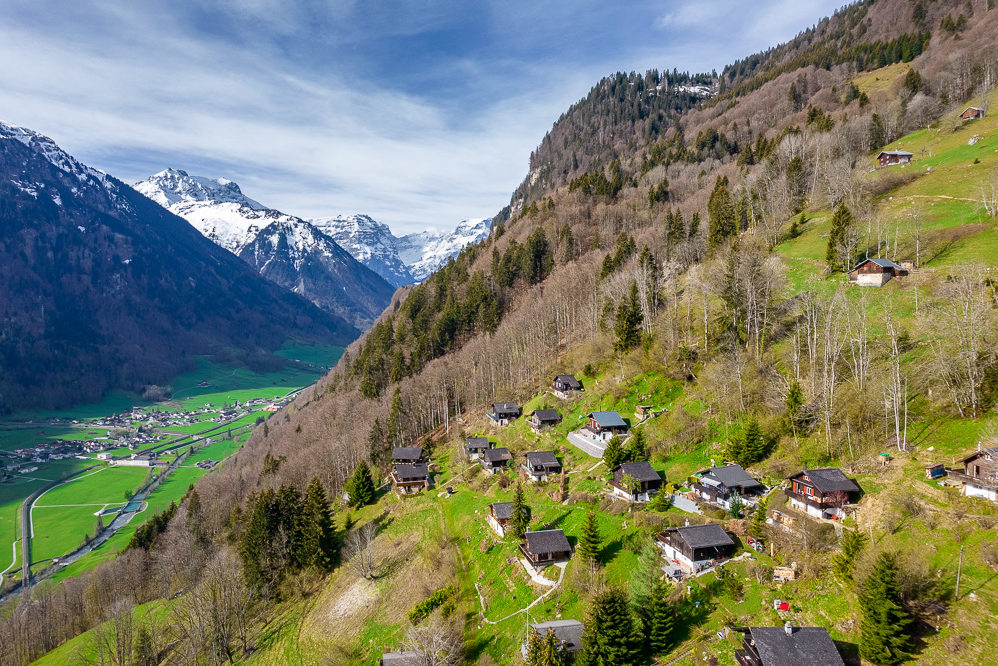Alpine Hügellandschaft mit verstreuten Chalets