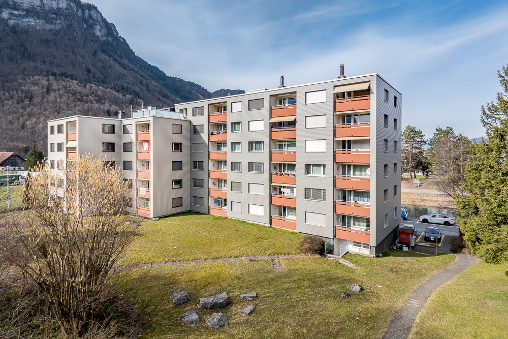 Mehrfamilienhaus mit Balkonfassade in alpiner Umgebung