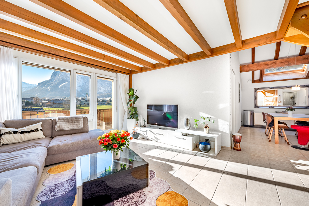 Wohnzimmer mit offener Essecke und Bergblick