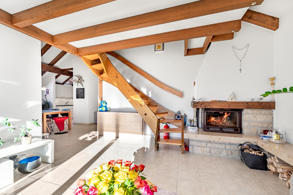 Wohnraum mit Kamin und Holztreppe