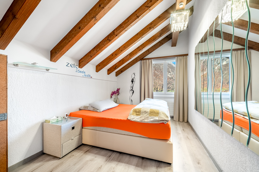 Helles Schlafzimmer mit sichtbaren Dachbalken