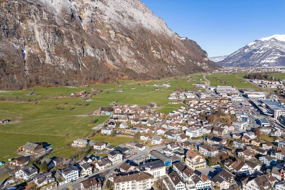 Luftaufnahme eines alpinen Tals mit Ortschaft