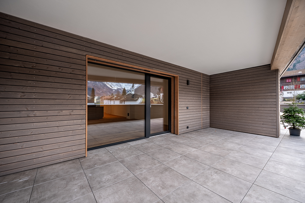 Überdachte Terrasse mit Schiebetür und Holzverkleidung