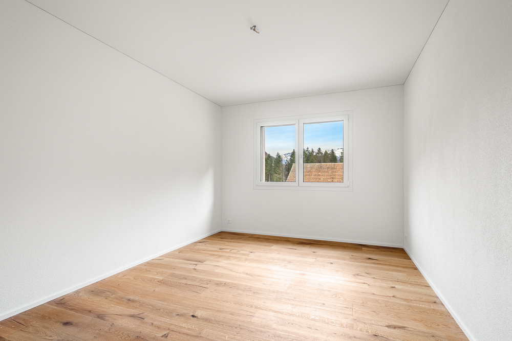 Leerer heller Raum mit Holzboden und Fenster