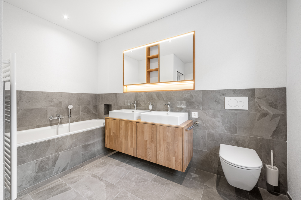 Modernes Badezimmer mit Wanne, Doppelwaschtisch und wandhängendem WC