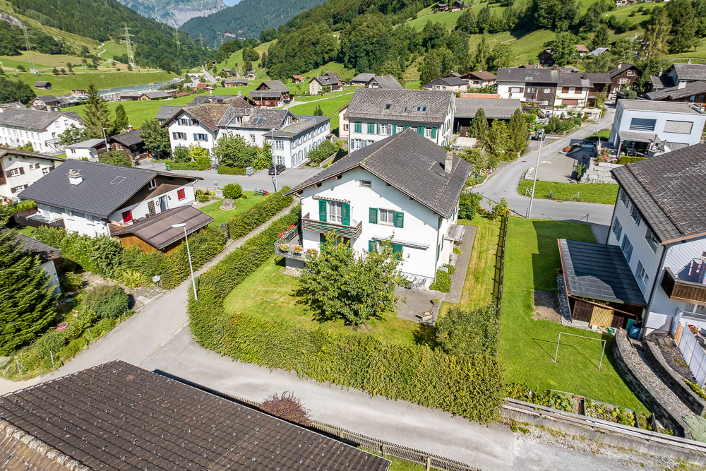 Luftaufnahme eines Wohnhauses im alpinen Dorf