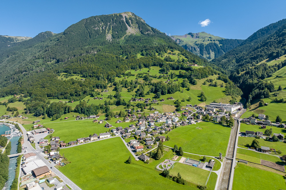 Alpines Tal mit Ortschaft und Bergen