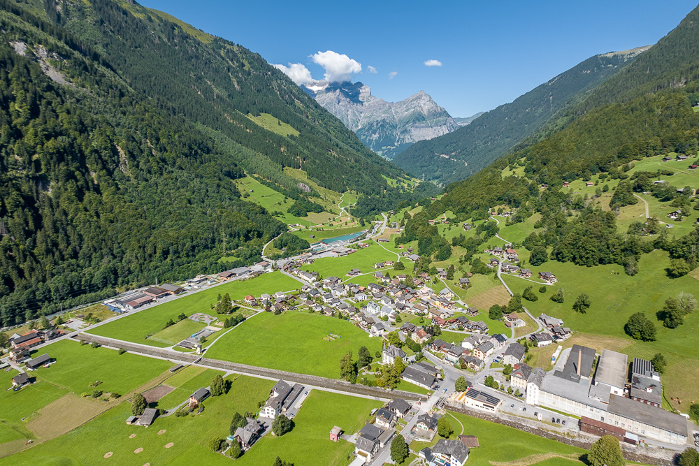 Alpen-Tal mit Dorf und Bergkulisse