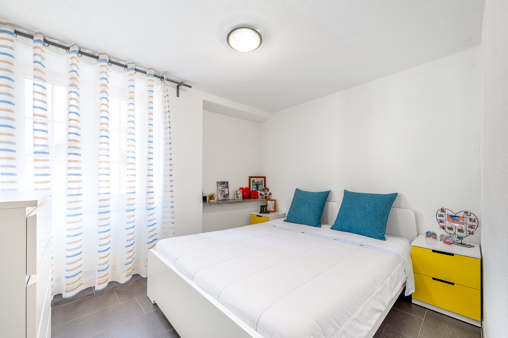 Helles Schlafzimmer mit weißen Wänden und farbigen Akzenten