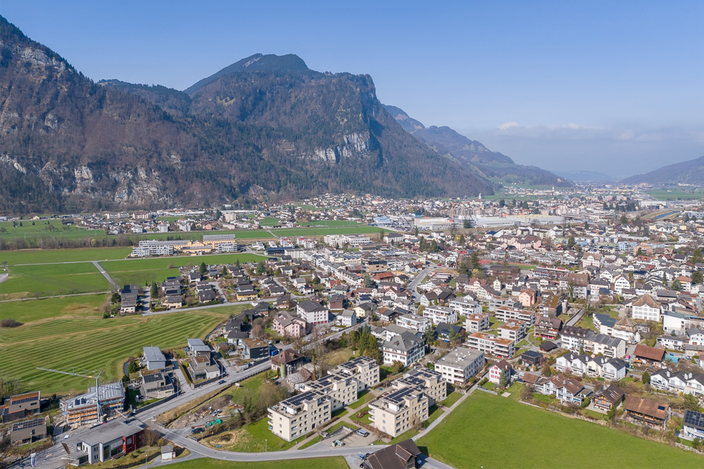 Luftaufnahme einer alpinen Stadt mit Tal und Bergen