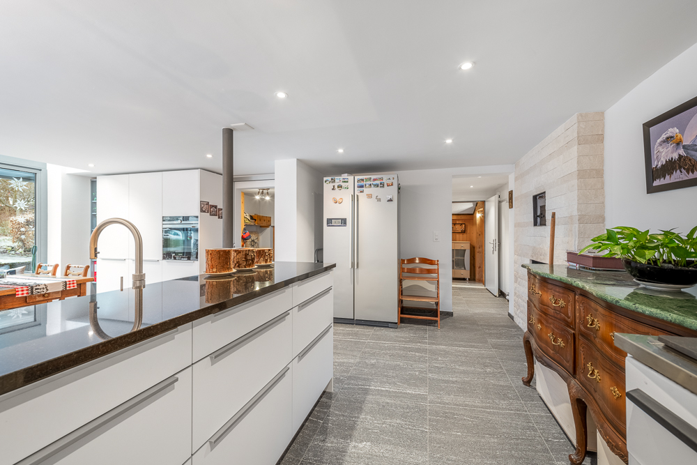 Moderne offene Küche mit Essbereich und Kamin