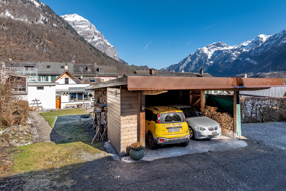 Außenansicht mit Carport und Bergkulisse