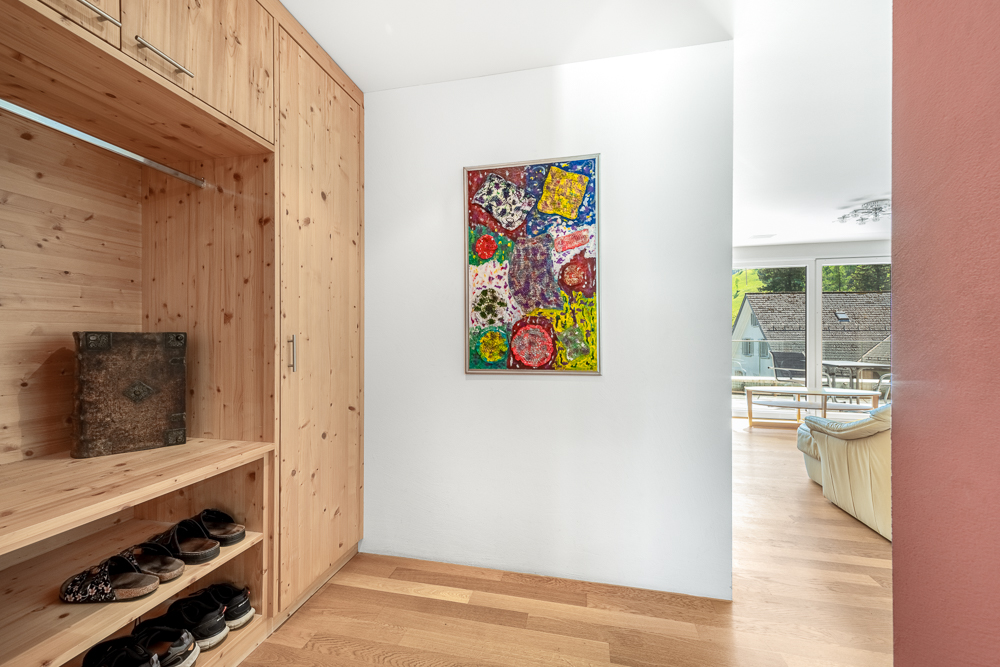 Heller Flur mit Holz-Einbauschrank und Blick in den Wohnbereich