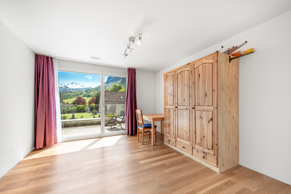 Helles Schlafzimmer mit Balkonblick und großem Kleiderschrank
