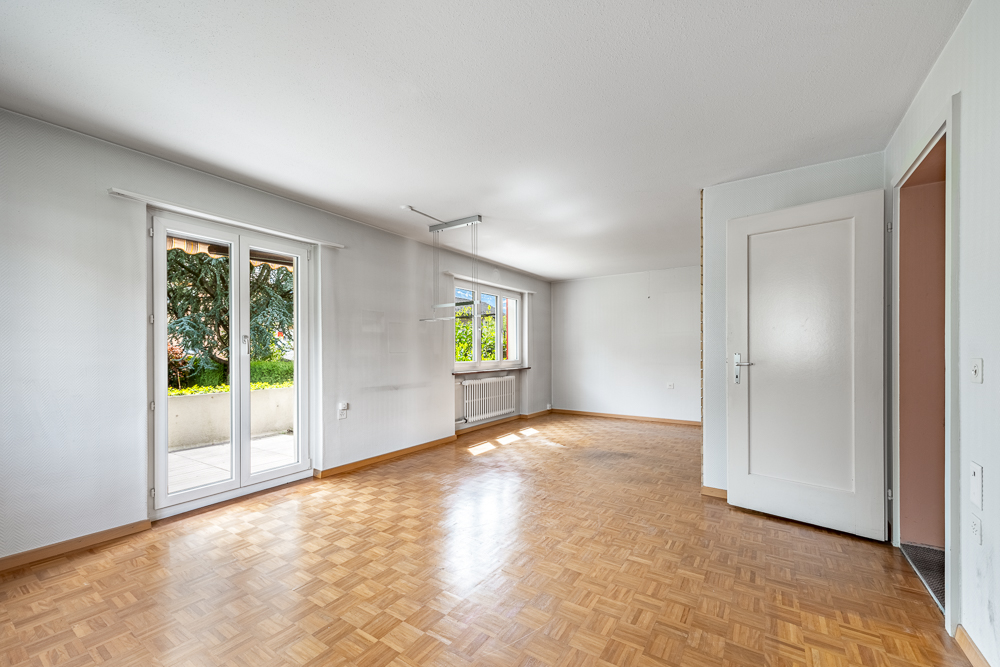 Leerer Wohnraum mit Balkonzugang
