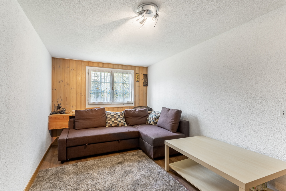 Kleines Wohnzimmer mit Holzpaneel-Rückwand