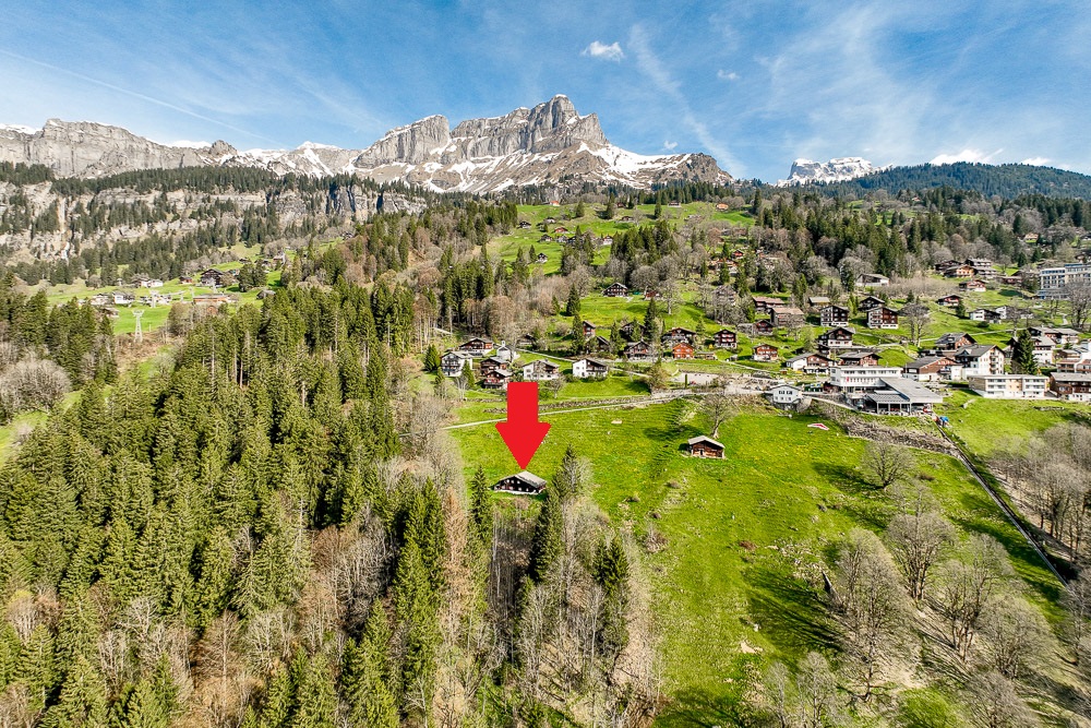 Alpine Luftaufnahme eines Bergdorfs mit markiertem Gebäude