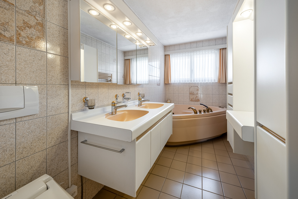 Helles Badezimmer mit Doppelwaschtisch und Eckwanne