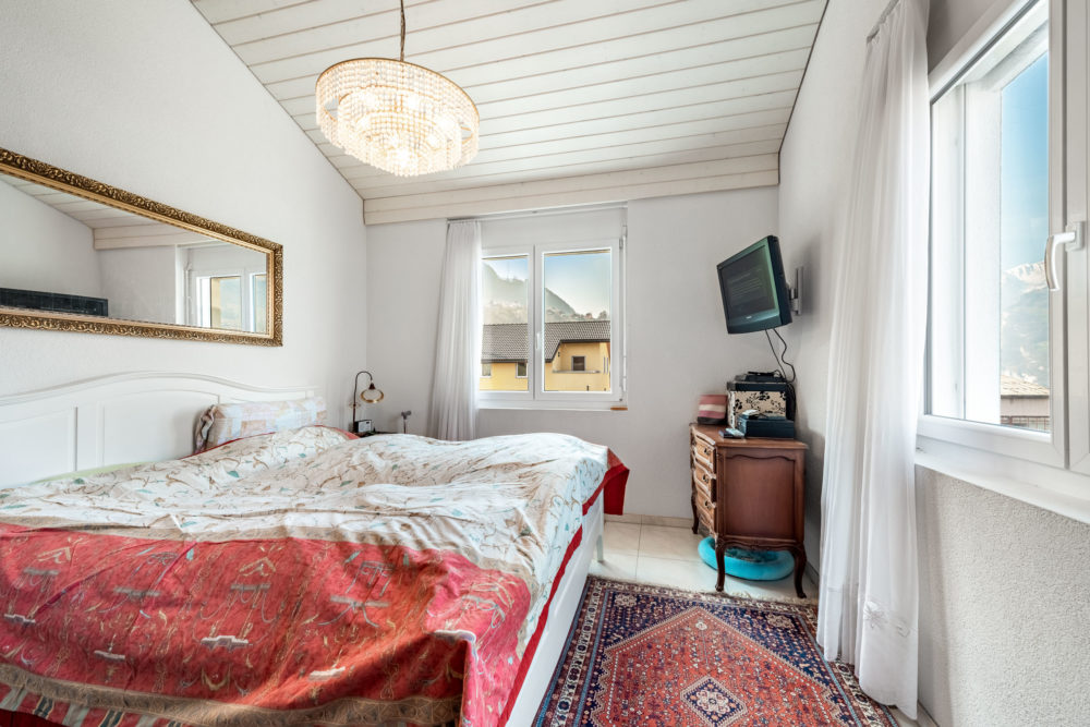 Helles Schlafzimmer mit Fensterblick und Teppichläufern