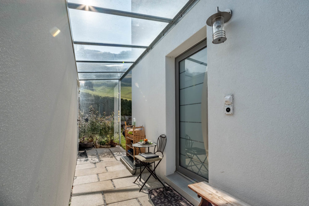Überdachter Außenbereich neben dem Haus