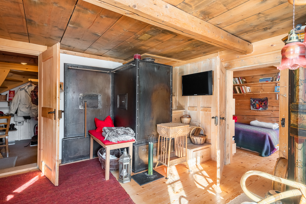 Gemütlicher Holzraum mit Ofen und Schlafnischen
