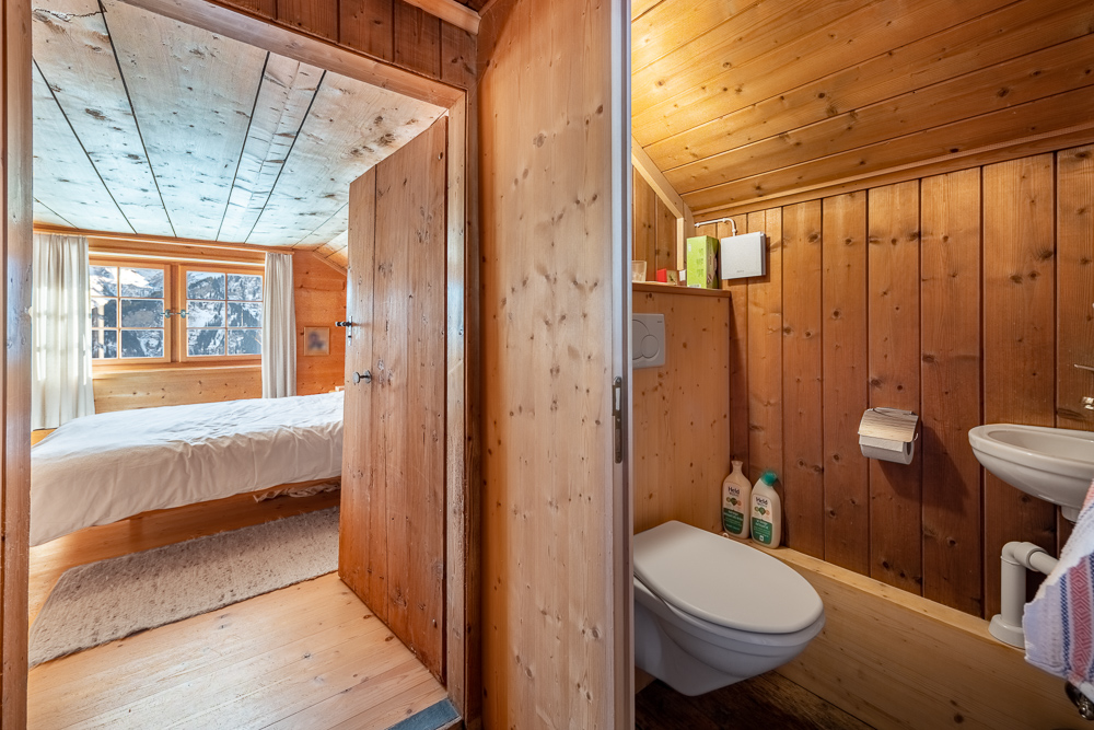 Holzvertäfeltes Schlafzimmer mit angrenzendem WC