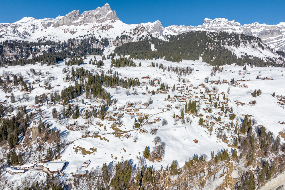 Alpine Schneelandschaft mit Weiler und Bergpanorama