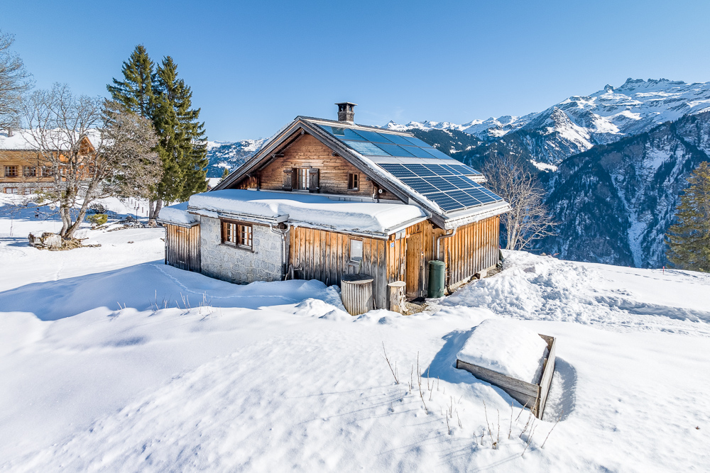 Alpine Hütte im Schnee mit Solardach