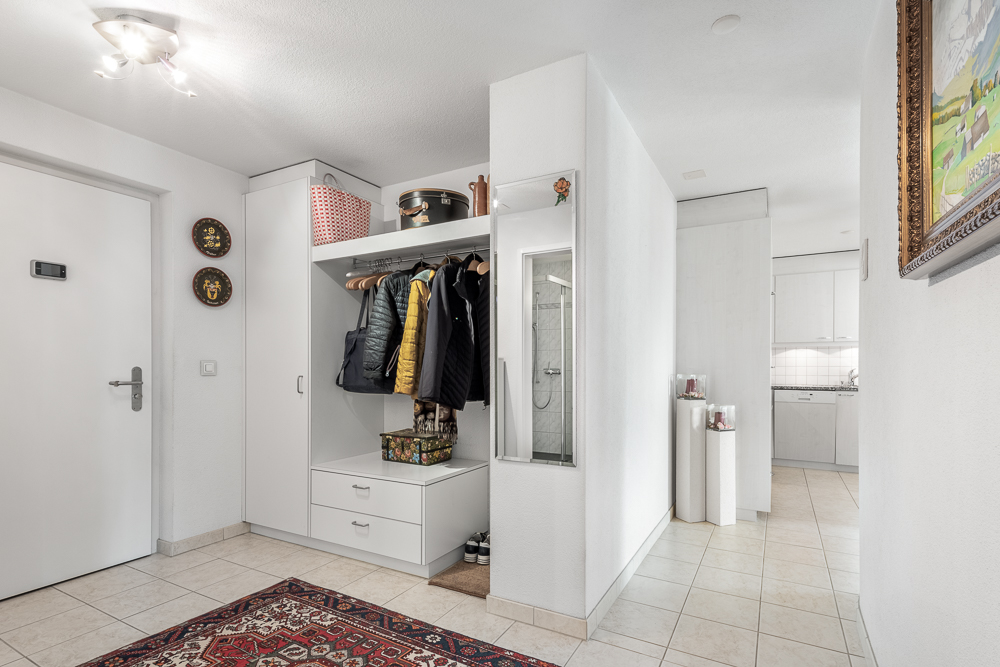 Heller Eingangsbereich mit Garderobe und Blick in die Küche