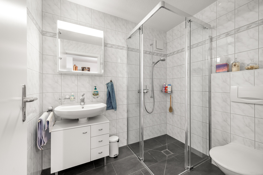 Modernes Badezimmer mit Glasdusche und Waschtisch