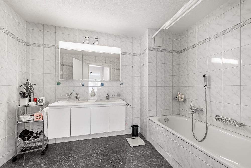 Helles Badezimmer mit Wanne und Doppelwaschtisch