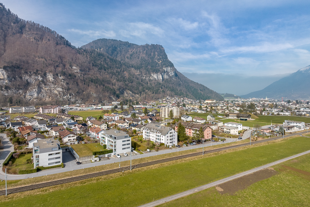 Luftaufnahme einer alpinen Kleinstadt mit Bergen