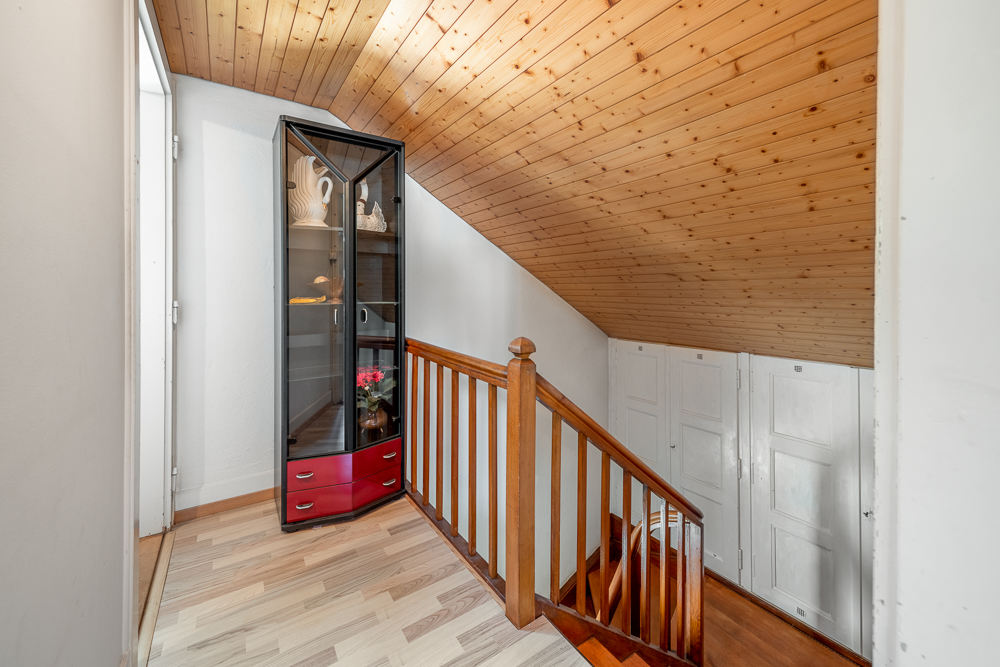 Dachgeschossflur mit Holzdecke und Treppenabgang