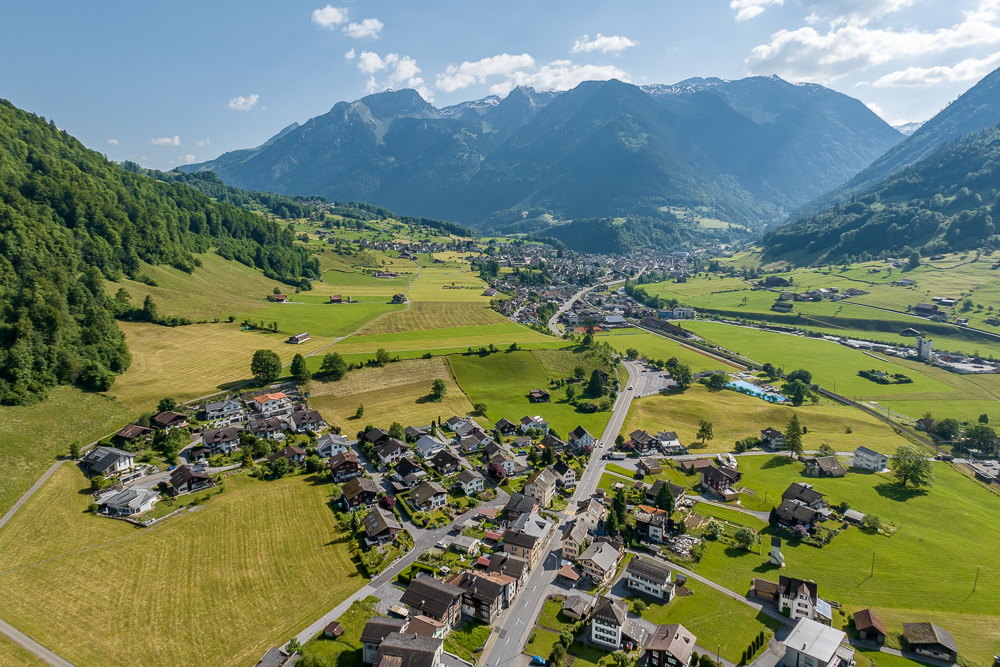 Alpenlandschaft mit Talort aus der Luft