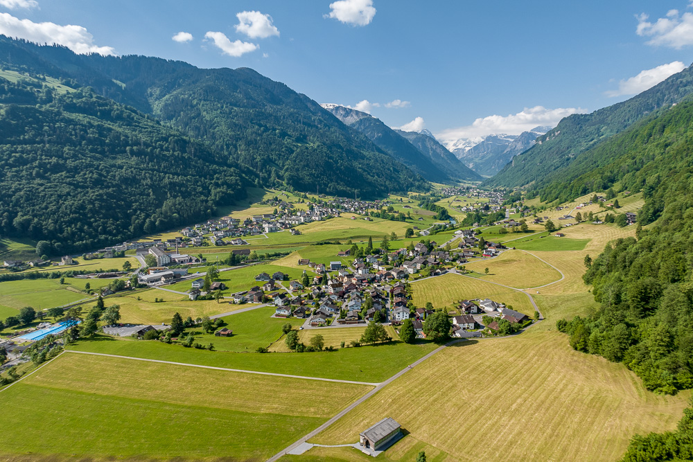 Alpen-Tal mit Ortschaft und Bergpanorama