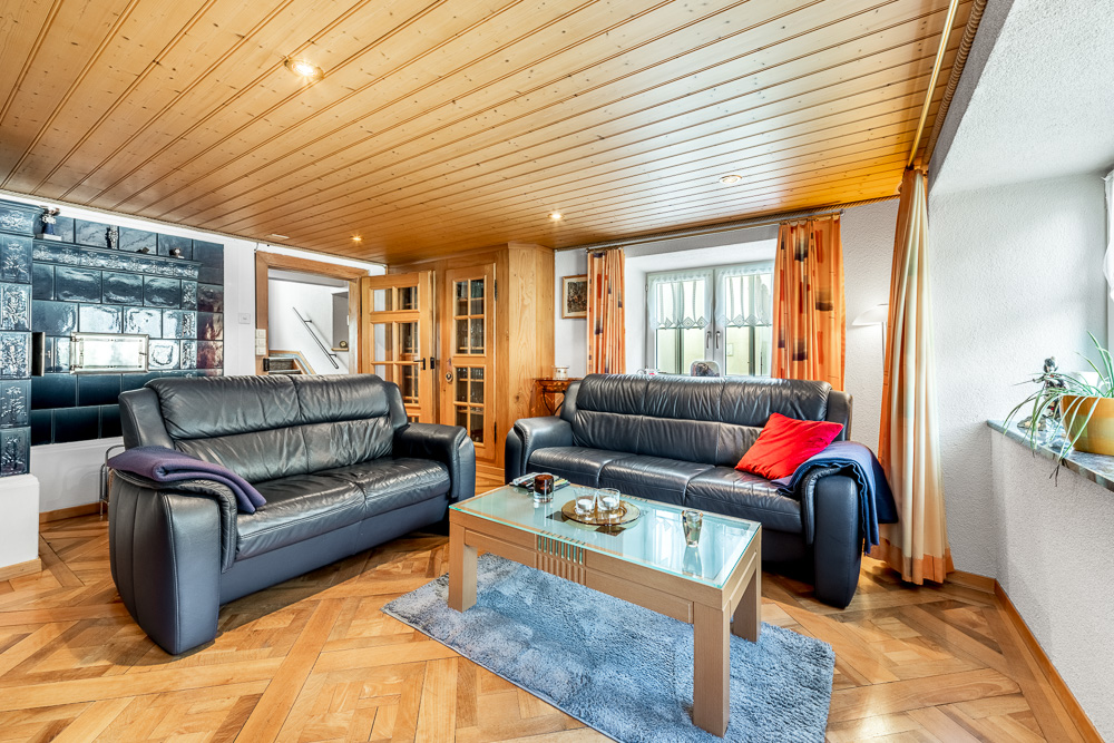 Wohnzimmer mit zwei Ledersofas und Holzkassettendecke
