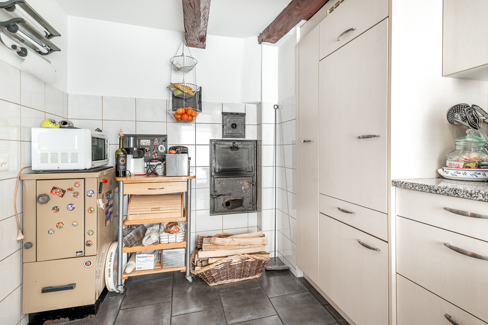 Kleine Küche mit Holzofen und Einbauten