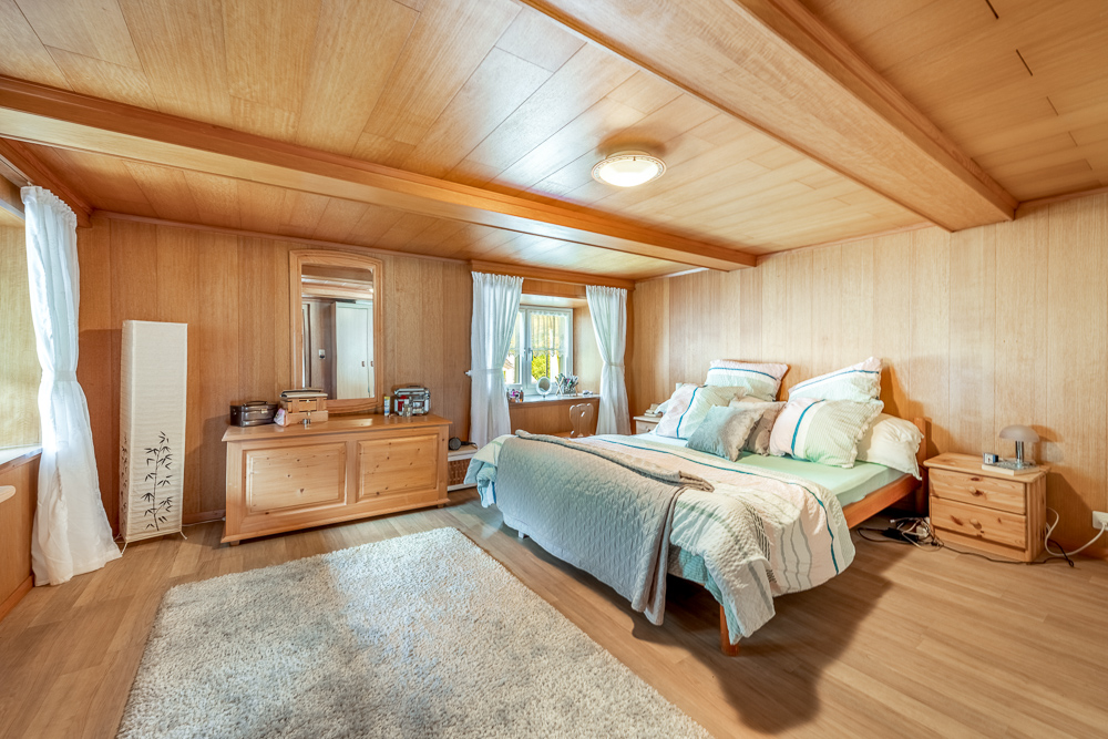 Gemütliches Schlafzimmer mit Holzvertäfelung