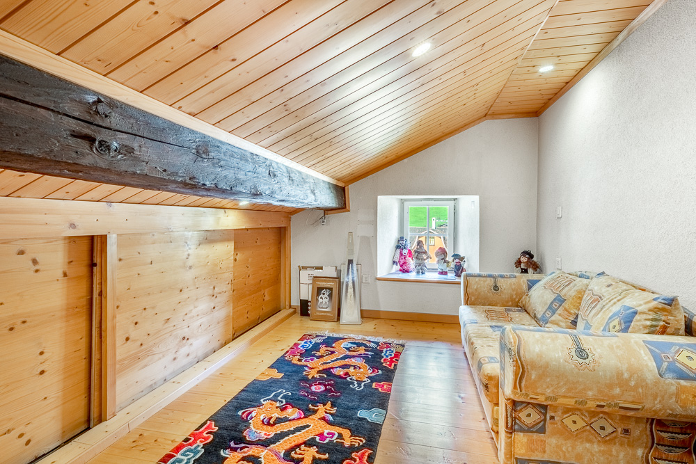 Dachzimmer mit sichtbaren Holzbalken