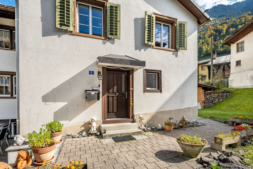 Eingangsbereich eines Hauses mit Garten und Bergkulisse