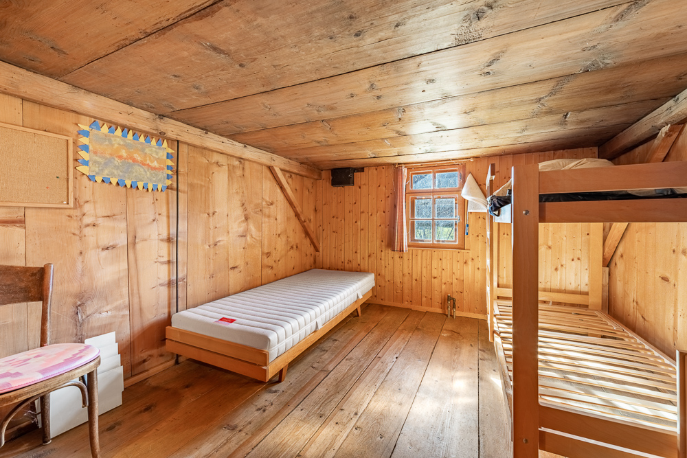 Rustikales Holzschlafzimmer mit Bett und Etagenbett