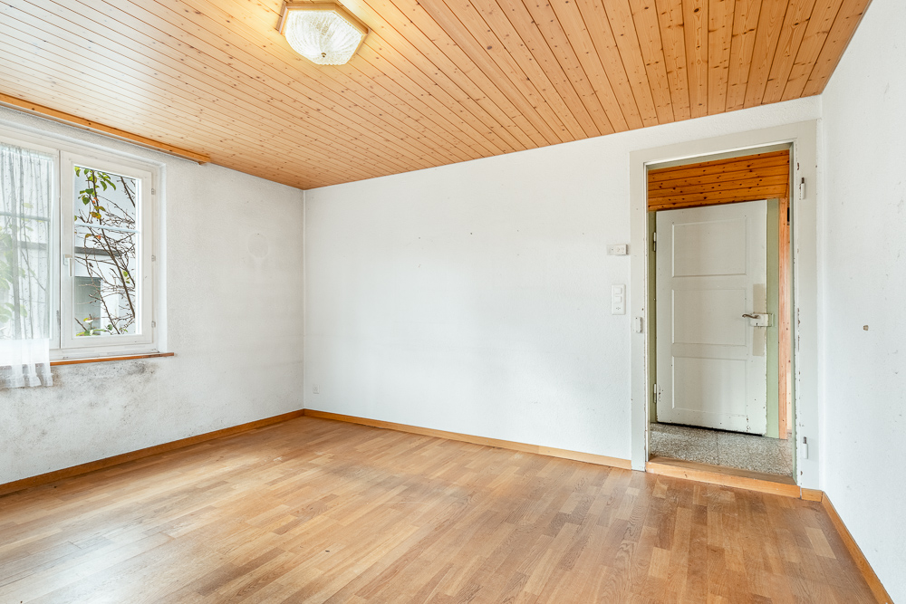Leerer Raum mit Holzdecke und Laminatboden