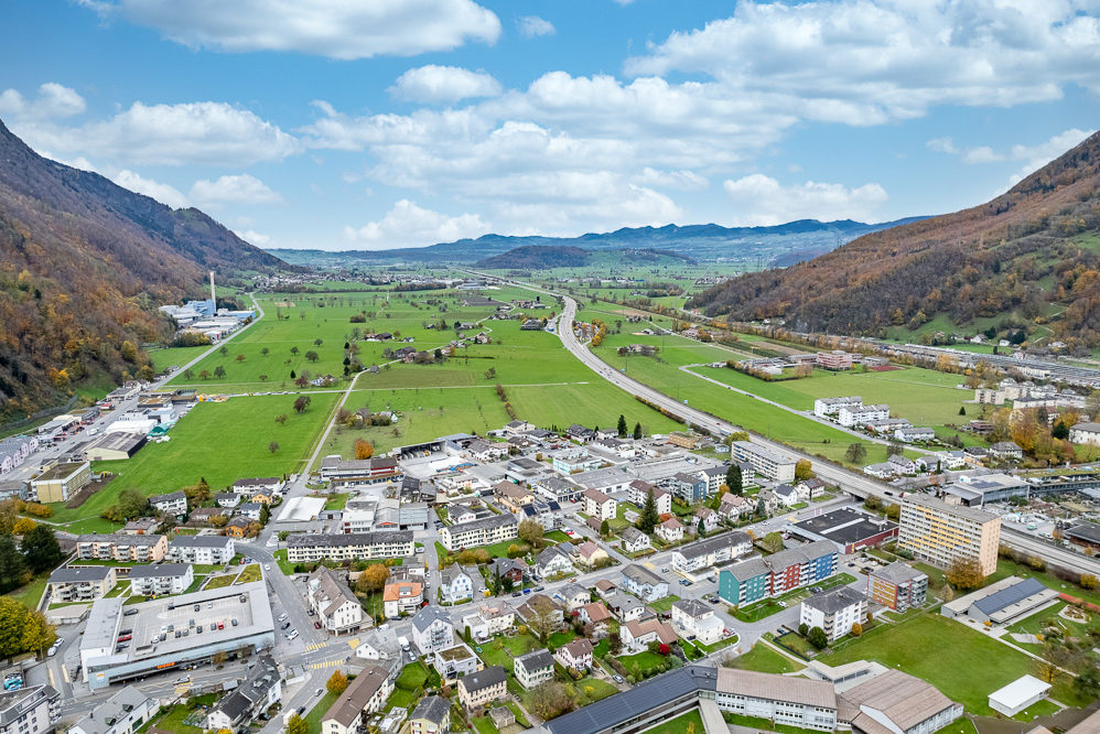 Luftaufnahme eines Tals mit Siedlung und Flussverlauf
