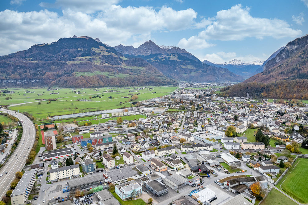 Luftaufnahme einer Stadt in einem Alpen-Tal